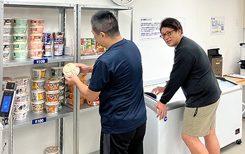 二人の男性が購入する商品を話し合っている様子
